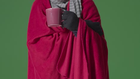 Close-Up-Of-Person-Wearing-Blanket-And-Gloves-With-Hot-Drink-Trying-To-Keep-Warm-In-Energy-Crisis