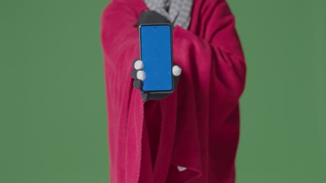 Close-Up-Of-Cold-Person-Wearing-Blanket-Holding-Blue-Screen-Mobile-Phone-Trying-To-Keep-Warm-In-Energy-Crisis