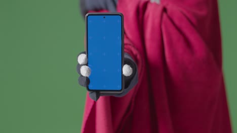 Close-Up-Of-Cold-Person-Wearing-Blanket-Holding-Blue-Screen-Mobile-Phone-Trying-To-Keep-Warm-In-Energy-Crisis-1