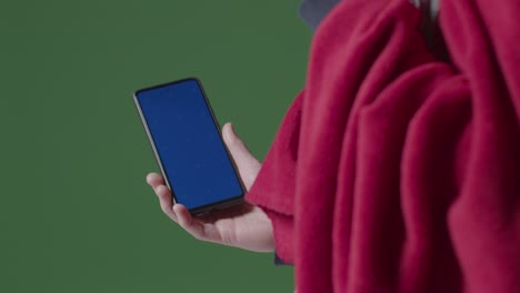 Close-Up-Of-Cold-Person-Wearing-Blanket-Holding-Blue-Screen-Mobile-Phone-Trying-To-Keep-Warm-In-Energy-Crisis-2