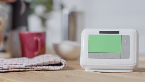 Person-Making-Hot-Drink-In-Kitchen-At-Home-With-Green-Screen-Smart-Meter-In-Foreground