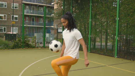 Young-Woman-On-Artificial-Soccer-Pitch-In-Urban-City-Area-With-Controlling-And-Kicking-Football-1