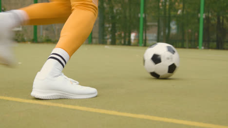 Pareja-Joven-Pateando-Fútbol-En-Un-Campo-De-Fútbol-Artificial-En-El-área-Urbana-De-La-Ciudad