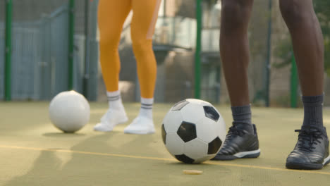Close-Up-Of-Players-Practising-Ball-Control-On-Artificial-Soccer-Pitch-In-Urban-City-Area-