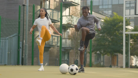 Male-And-Female-Players-Exercising-And-Warming-Up-On-Artificial-Soccer-Pitch-In-Urban-City-Area-