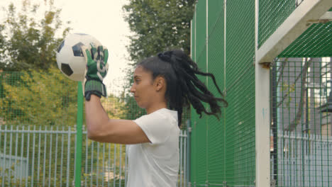 Female-Goalkeeper-Training-Saving-Shots-In-Goal-On-Artificial-Football-Pitch-In-Urban-City-Area-