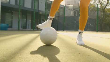Close-Up-Of-Female-Football-Player's-Feet-Practising-Ball-Control-On-Artificial-Soccer-Pitch-In-Urban-City-Area-