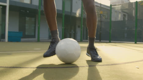 Close-Up-Of-Male-Football-Player's-Feet-Practising-Ball-Control-On-Artificial-Soccer-Pitch-In-Urban-City-Area-