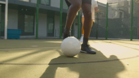 Close-Up-Of-Players-Practising-Ball-Control-On-Artificial-Soccer-Pitch-In-Urban-City-Area-1