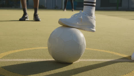 Close-Up-Of-Young-Woman-Placing-Football-On-Centre-Circle-Of-Artificial-Soccer-Pitch-In-Urban-City-For-Kick-Off-2