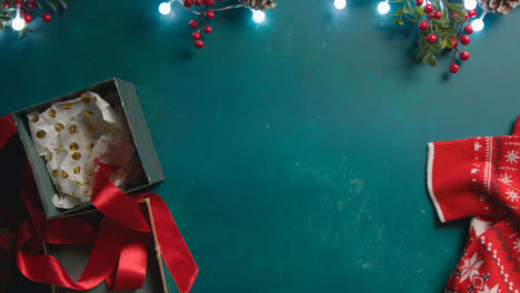 Overhead-Aufnahme-Von-Weihnachtsbeleuchtung-Mit-Beeren-Und-Geschenkverpackung-Auf-Grünem-Hintergrund-1