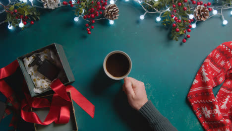 Overhead-Shot-Of-Person-With-Green-Screen-Mobile-Phone-With-Christmas-Decorations-And-Gifts-1