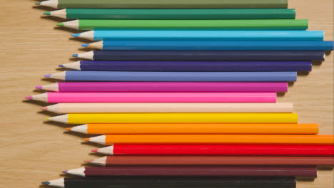 Lápices-De-Colores-Dispuestos-Geométricamente-En-Una-Línea-Sobre-Fondo-De-Madera