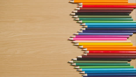 Lápices-De-Colores-Dispuestos-En-Un-Patrón-Simétrico-Sobre-Fondo-De-Madera-3