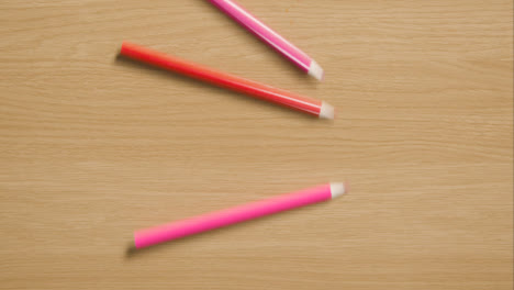 Mehrfarbige-Bleistifte,-Die-Den-Hölzernen-Hintergrund-Herunterrollen-1