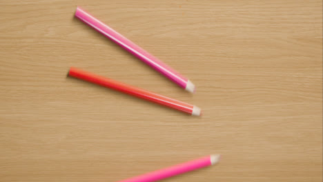 Mehrfarbige-Bleistifte,-Die-Den-Hölzernen-Hintergrund-Herunterrollen-2