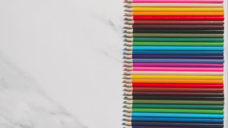 Lápices-De-Colores-Dispuestos-En-Línea-Sobre-Fondo-De-Mármol-Blanco