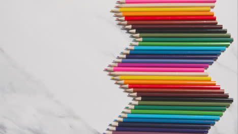Lápices-De-Colores-Dispuestos-En-Un-Patrón-Simétrico-Sobre-Fondo-De-Mármol-Blanco