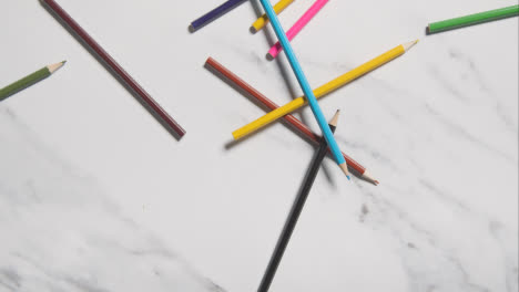 Mehrfarbige-Bleistifte,-Die-Auf-Marmorhintergrund-Fallen