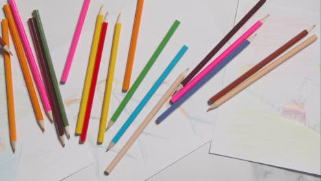 Overhead-Shot-Of-Child-With-Coloured-Pencils-And-Drawing-On-Marble-Background