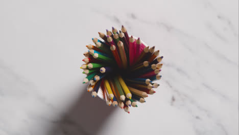 Overhead-Shot-Of-Multi-Coloured-Pencils-In-Pot-On-Marble-Background