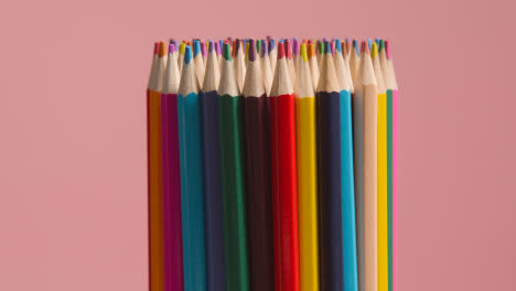 Studioaufnahme-Von-Rotierenden-Mehrfarbigen-Stiften-Vor-Rosa-Hintergrund