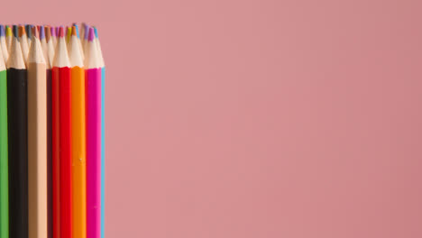 Studio-Shot-Of-Rotating-Multi-Coloured-Pencils-Against-Pink-Background-2