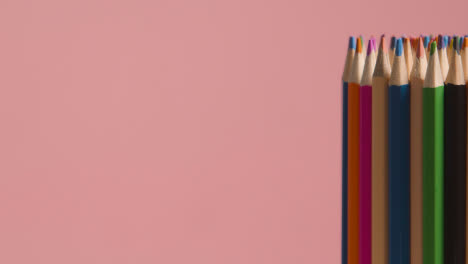 Studio-Shot-Of-Rotating-Multi-Coloured-Pencils-Against-Pink-Background-3