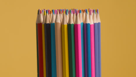 Studio-Shot-Of-Multi-Coloured-Pencils-Against-Yellow-Background-2