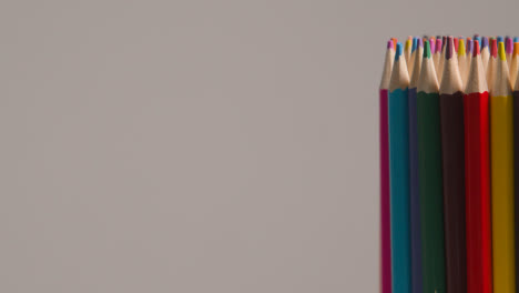 Studio-Shot-Of-Rotating-Multi-Coloured-Pencils-Against-Grey-Background-2