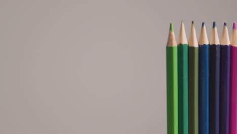 Studio-Shot-Of-Rotating-Line-Of-Multi-Coloured-Pencils-Against-Grey-Background-2