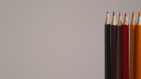 Studio-Shot-Of-Rotating-Line-Of-Multi-Coloured-Pencils-Against-Grey-Background-3