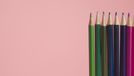Studioaufnahme-Einer-Rotierenden-Linie-Aus-Mehrfarbigen-Bleistiften-Vor-Rosafarbenem-Hintergrund