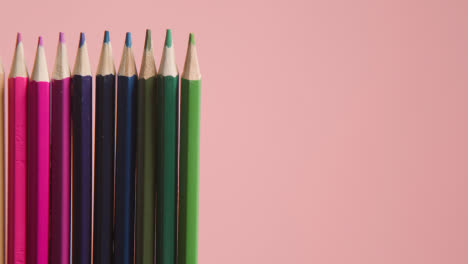 Studio-Shot-Of-Rotating-Line-Of-Multi-Coloured-Pencils-Against-Pink-Background-2