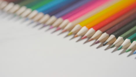 Studio-Shot-Of-Multi-Coloured-Pencils-In-A-Line-On-White-Background-