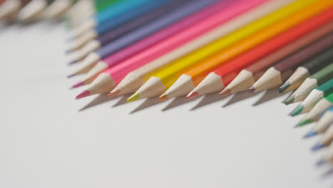 Studioaufnahme-Von-Mehrfarbigen-Bleistiften-In-Einer-Linie-Auf-Weißem-Hintergrund-Mit-Der-Hand,-Die-2-Auswählt