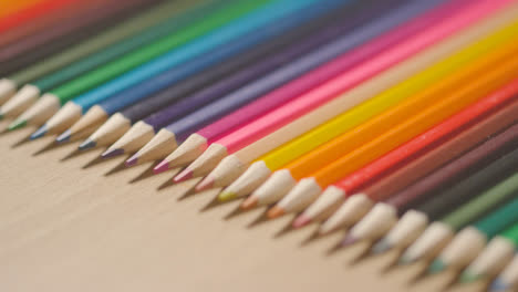 Studio-Shot-Of-Multi-Coloured-Pencils-In-A-Line-On-Wooden-Background-