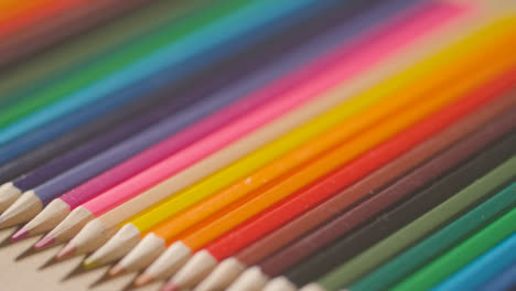 Studio-Shot-Of-Multi-Coloured-Pencils-In-A-Line-On-Wooden-Background-1