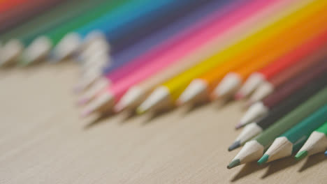 Studio-Shot-Of-Multi-Coloured-Pencils-In-A-Line-On-Wooden-Background-3
