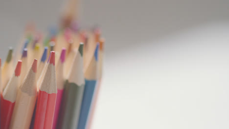 Close-Up-Of-Person-Dropping-Multi-Coloured-Pencils-Into-Pot