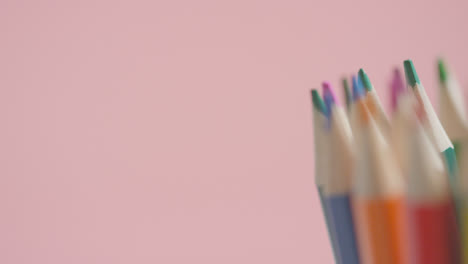 Studio-Shot-Of-Rotating-Multi-Coloured-Pencils-Against-Pink-Background-4