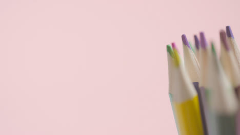 Studio-Shot-Of-Rotating-Multi-Coloured-Pencils-Against-Pink-Background-5