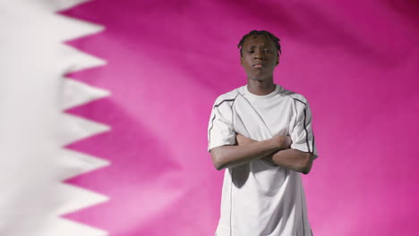 Young-Footballer-Walking-to-Camera-In-Front-of-Qatar-Flag-02