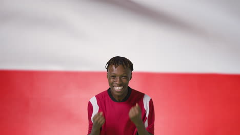 Young-Footballer-Celebrating-to-Camera-In-Front-of-Poland-Flag-01