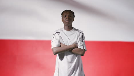 Young-Footballer-Walking-to-Camera-In-Front-of-a-Poland-Flag