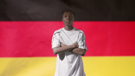 Junger-Fußballer,-Der-Vor-Deutschland-flagge-Aufwirft