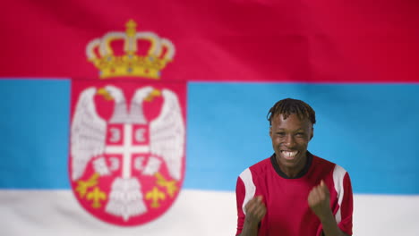 Young-Footballer-Celebrating-to-Camera-In-Front-of-Serbia-Flag-01