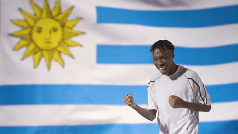 Young-Footballer-Celebrating-to-Camera-In-Front-of-Uruguay-Flag-01