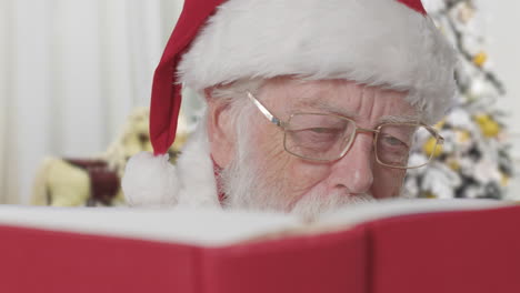 Santa-Claus-Leyendo-Un-Libro-Rojo