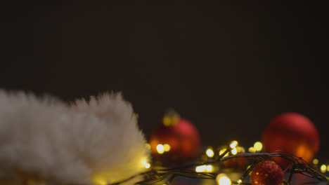 Urlaubskonzept-Mit-Rotierenden-Weihnachtsbaumbeleuchtungen-Und-Weihnachtsmützen-Auf-Schwarzem-Hintergrund
